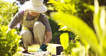 woman bending knees in her garden